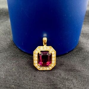 GOLD PENDANT WITH EMERALD CUT CENTER STONE AND CZS